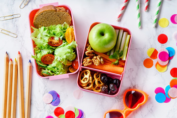 Wall Mural - Lunch box with salad and healthy food for school. Top view image with color pencils and children's glasses