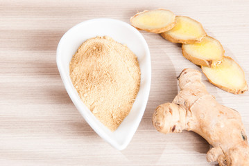 Wall Mural - Ginger root and ginger powder on wooden background