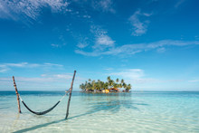 Hammock In Sea And Little Island With Palms Between Water Surface