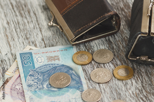 Fotografía Polish zloty with little wallets on the old wooden background