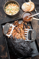 Wall Mural - Traditional barbecue pulled pork piece of Bosten butt torn to bits with coleslaw and burger as top view on a board