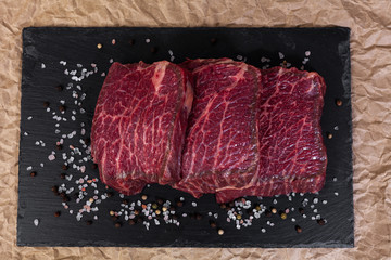 The cut of marbled beef on slate and butcher paper