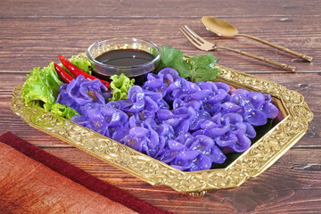 Royal Thai cuisine : Purple blue color Flower-shaped Thai dumpling (Khanom Chor Muang) Famous ancient Thai appetizers.(Purple / Blue color from the Asian pigionwings flower(Butterfly / Darwin pea))