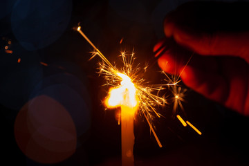 family party woman holding and playing with fire sparklers on the festival