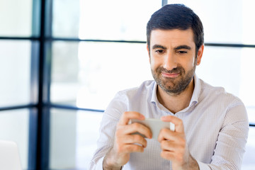 Poster - Confident young man in smart casual wear holding phone