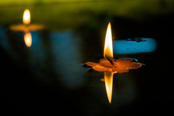 Yellow Flower Candle burning floating in water.