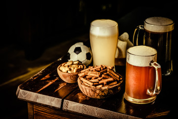 Canvas Print - Selection of different types of beer and salty snacks s in pub, copy space with soccer ball, football championship concept