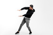 © Leika production - Dark-haired young man wearing a black sweatshirt and gray pants is dancing street dance. He makes stylized movements with his hands