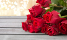 Flowers, Valentines Day And Holidays Concept - Close Up Of Red Roses Bunch On Wooden Boards Over Festive Lights Background