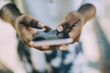 © Maskot - Midsection of young woman using smart phone while standing outdoors
