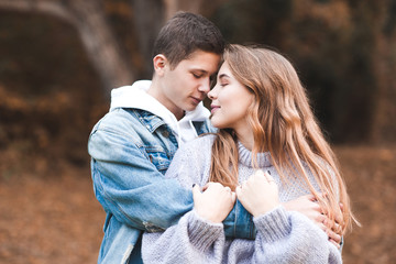 Love teenage couple holding each other outdoors. Happy together. 20s.