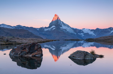 Fototapete - The famous Matterhorn reflected in the Stellisee during dawn. Zermatt, Switzerland.