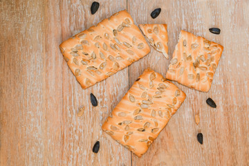 Cookies made from wheat and oatmeal flour with organic sunflower seeds, healthy and diet food on wooden background, vintage