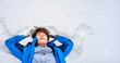 © Mihail - young male teenager in casual lying on the snow on a winter day f