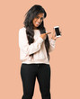 © luismolinero - Young afro american woman showing the mobile on isolated brown background