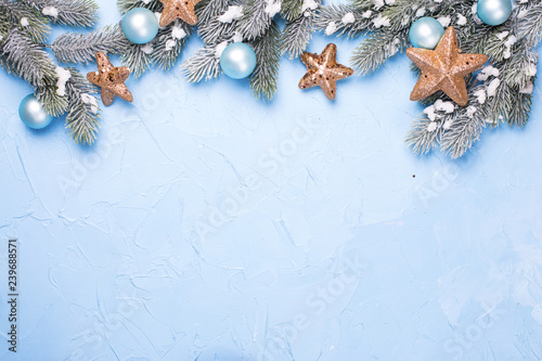 Fotografie, Obraz Decorative branches fir tree, golden stars and blue balls on blue textured background