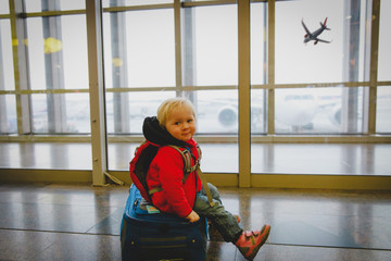 cute little baby girl on suitcase travel in airport