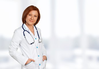 Attractive young female doctor with blurred hospital