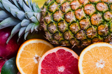 whole pineapple with citrus fruits close