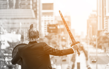 business warrior or business concept. new work for young businessman holding a sword and shield standing imagination on warrior for life, hope,and preparation, protection, precaution. Black and White