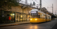 Public transportation concept. Yellow electric tram at Berlin, Germany. Cloudy sky background.