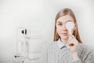 Young woman reception doctor ophthalmologist to check quality of eye vision.