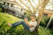 © Fabio Principe - Young boy alone playing with smartphone. Pre teen with glasses sitting outdoor play with phone in hand. The use of the smartphone isolates the boy from the surrounding reality.