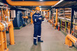 © dusanpetkovic1 - Young Caucasian man in protective suit using tablet while standing in heating plant.