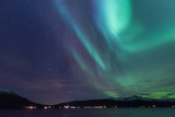 Fototapeta Tęcza - The polar arctic Northern lights aurora borealis sky star in Scandinavia Norway Tromso in the farm winter forest  
