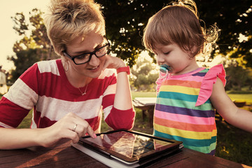 Sticker - mom and her little daughter using tablet computer