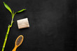 Asian spa treatments with natural ingredients concept. Bamboo branch, spa cosmetics on black background top view copy space