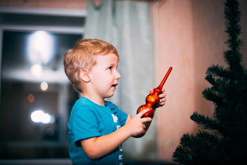 Wall Mural - little baby decorates the Christmas tree