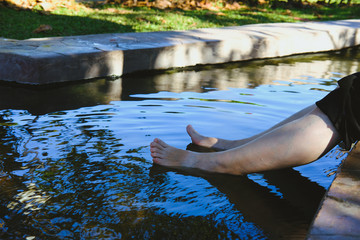 woman soaking feet in hot mineral spring water