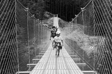 People on a suspension bridge in the mountains near the village of Perarollo di Cadore.