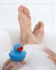 Wall Mural - Men's feet in a bathtub, selective focus on toes