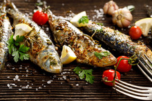 Fried Fishes With Addition Of Herbs, Spices And Lemon Slices On A Wooden Background. 