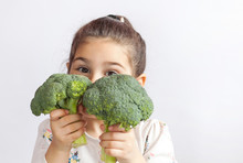 Happy Smiling Child Girl Eating Vegetables. Healthy Food. Fresh Broccoli.