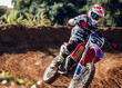 © ADDICTIVE STOCK - Man in helmet riding motorcycle on dirt road during race