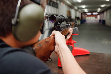 Canvas Print - Automatic weapons aim firing gun pistol man with loading cartridges. Shooting range