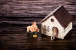 Led lamps and piggy bank lie on a near the house layout wooden background