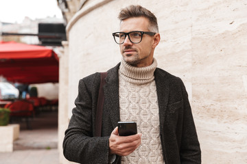 Canvas Print - Handsome man wearing a coat walking