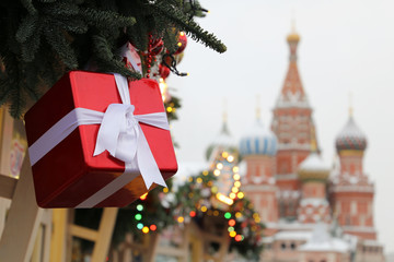 Wall Mural - Christmas fair on Red Square in Moscow, New Year celebration in Russia. Christmas trees on background of St. Basil's Cathedral, festive decorations during snowfall