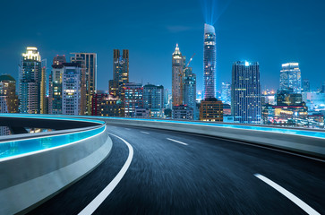 Curvy flyover highway moving forward road with Bangkok cityscape night scene view . motion blur effect apply