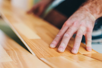 Wall Mural - The master skillfully installs parquet - floating floor - floor work during finishing