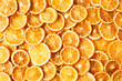Natural dried oranges or dried grapefruit background. Sliced and dried candied citrus fruit background. Food background. Top view with copy space for text. Flat lay.