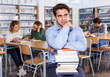 © JackF - upset man with stack of books in hands