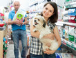 © JackF - Positive female with dog in pet shop, during shopping with man