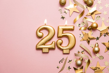 Wall Mural - Number 25 gold celebration candle on star and glitter background