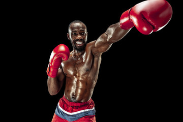 Hands of boxer over black background. Strength, attack and motion concept. Fit african american model in movement. Afro muscular athlete in sport uniform. Sporty man during boxing