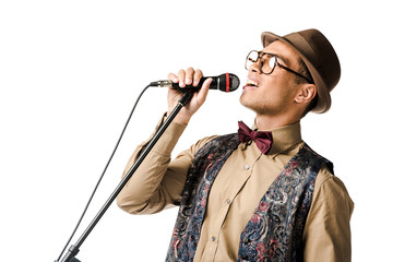 Wall Mural - close up shot of emotional stylish mixed race male musician holding microphone and singing isolated on white